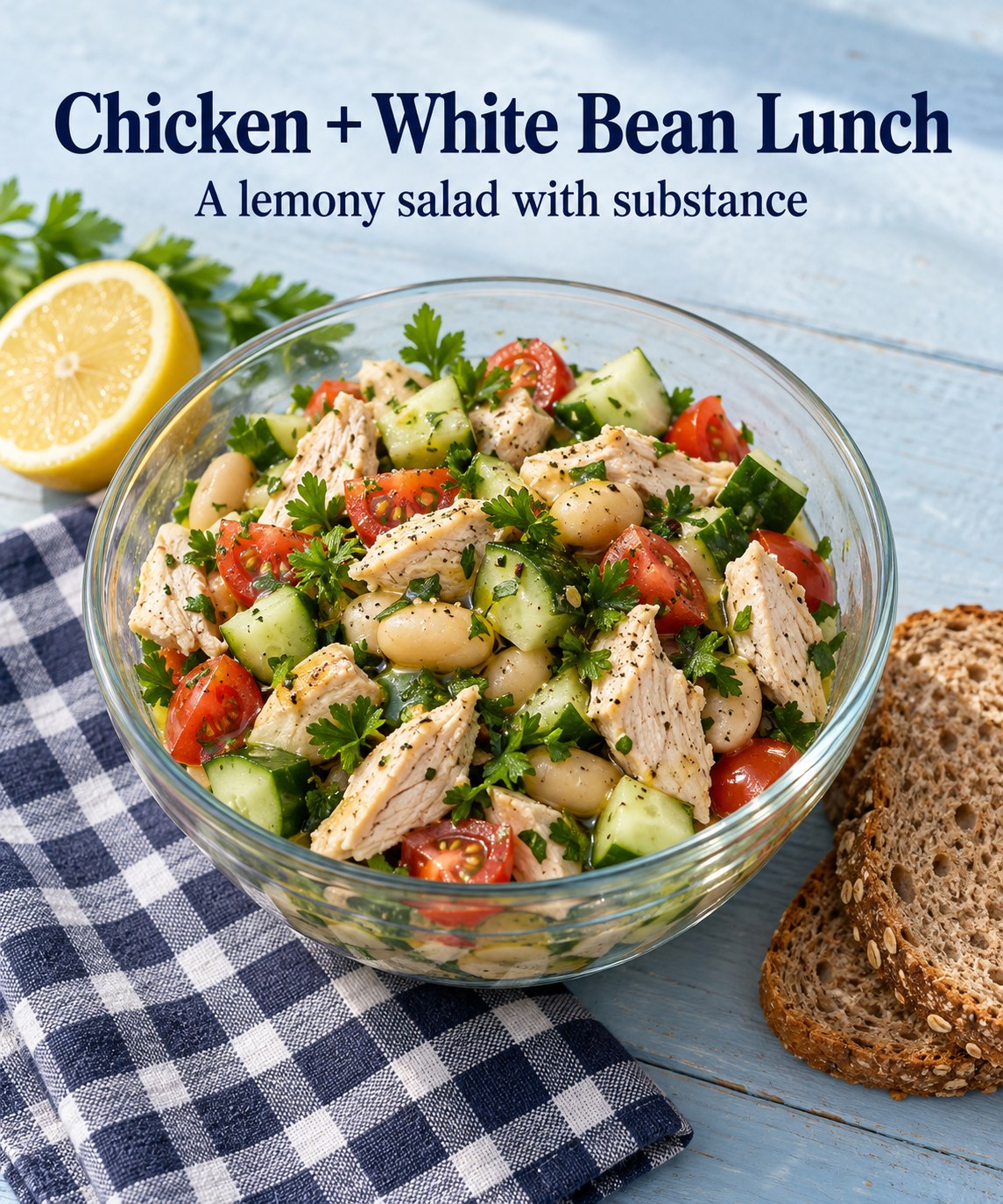 Chicken and white bean salad with cucumber, tomatoes, parsley, and lemon beside bread.